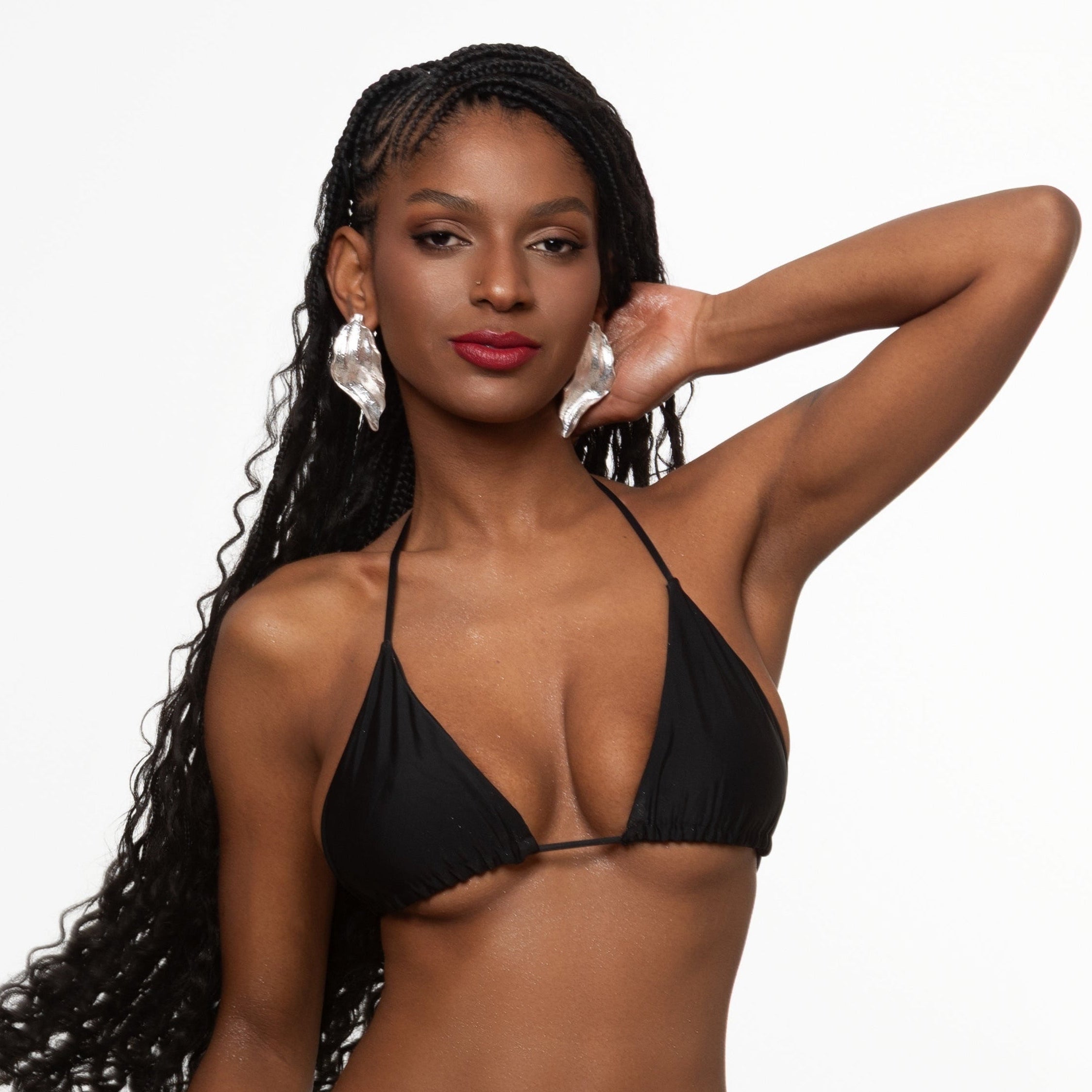 This image features a model sporting a classic black triangle bikini top. The design is minimalistic, emphasizing a sleek and timeless appeal with its simple triangle shape and thin straps.
