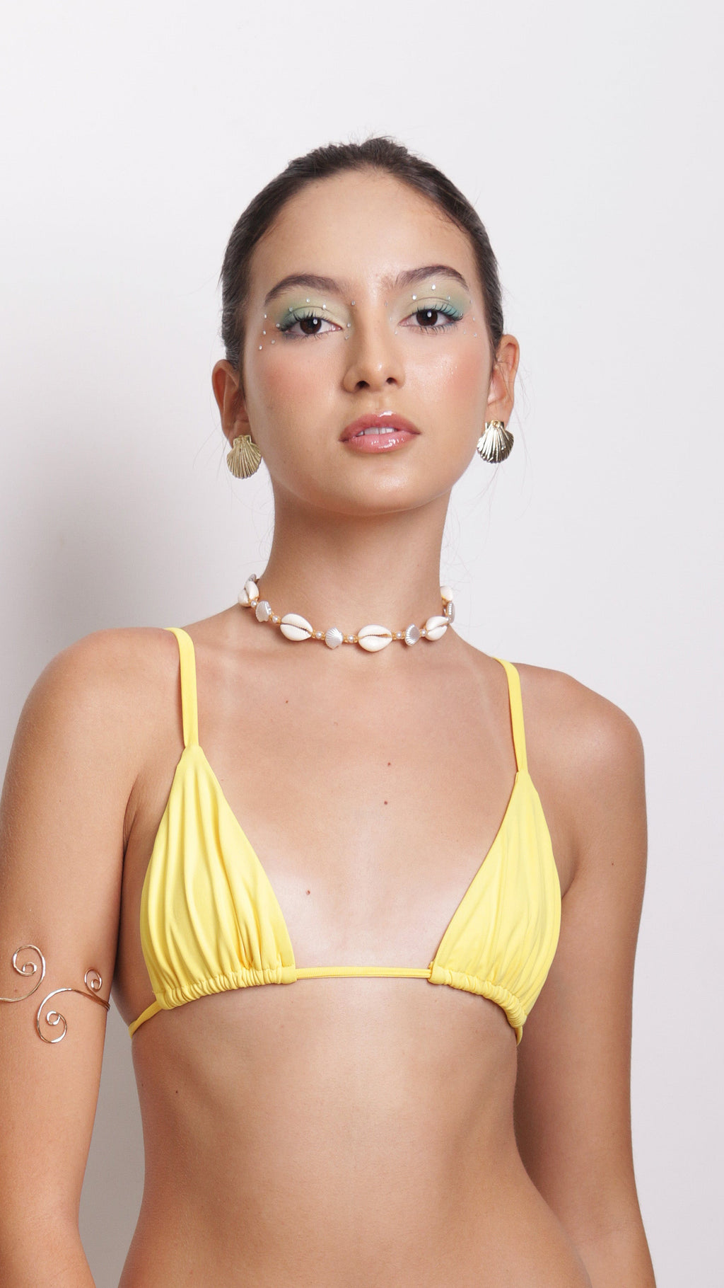 Woman wearing a yellow bikini against a plain background