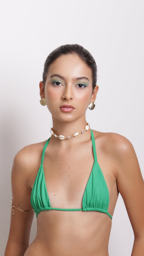 Woman wearing a green bikini against a white background